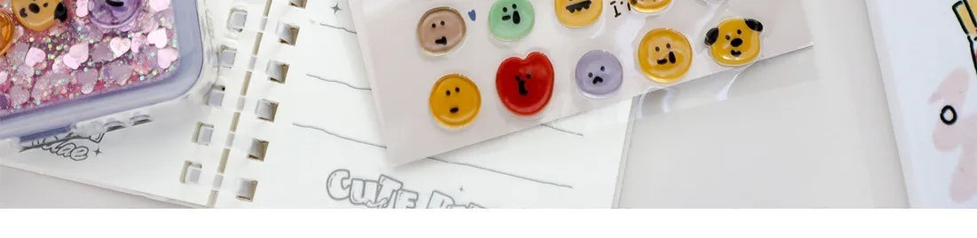 A collection of colorful 3D smile face crystal stickers for crafting and decorating arranged on a sheet of paper.