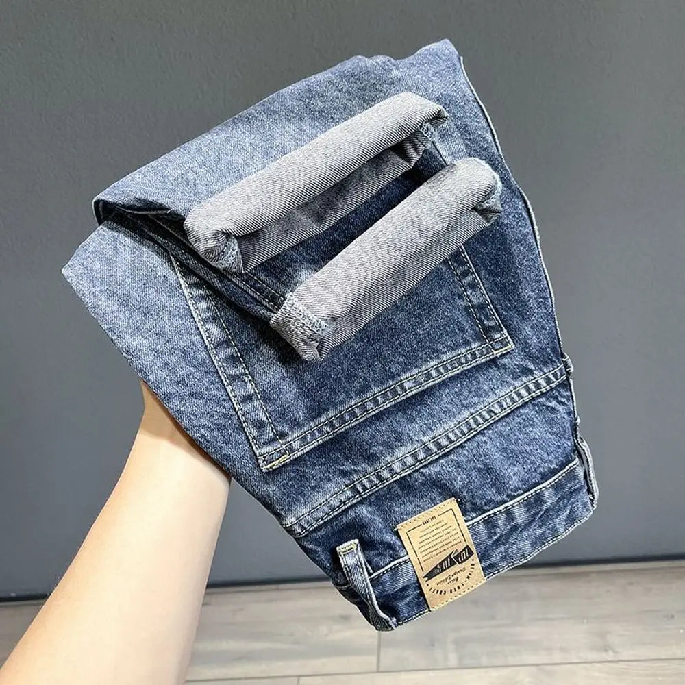 A pair of vintage loose fit denim harem jeans folded and displayed against a gray background.