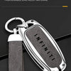 A silver key case cover made of fashionable zinc alloy material with a black textured strap.