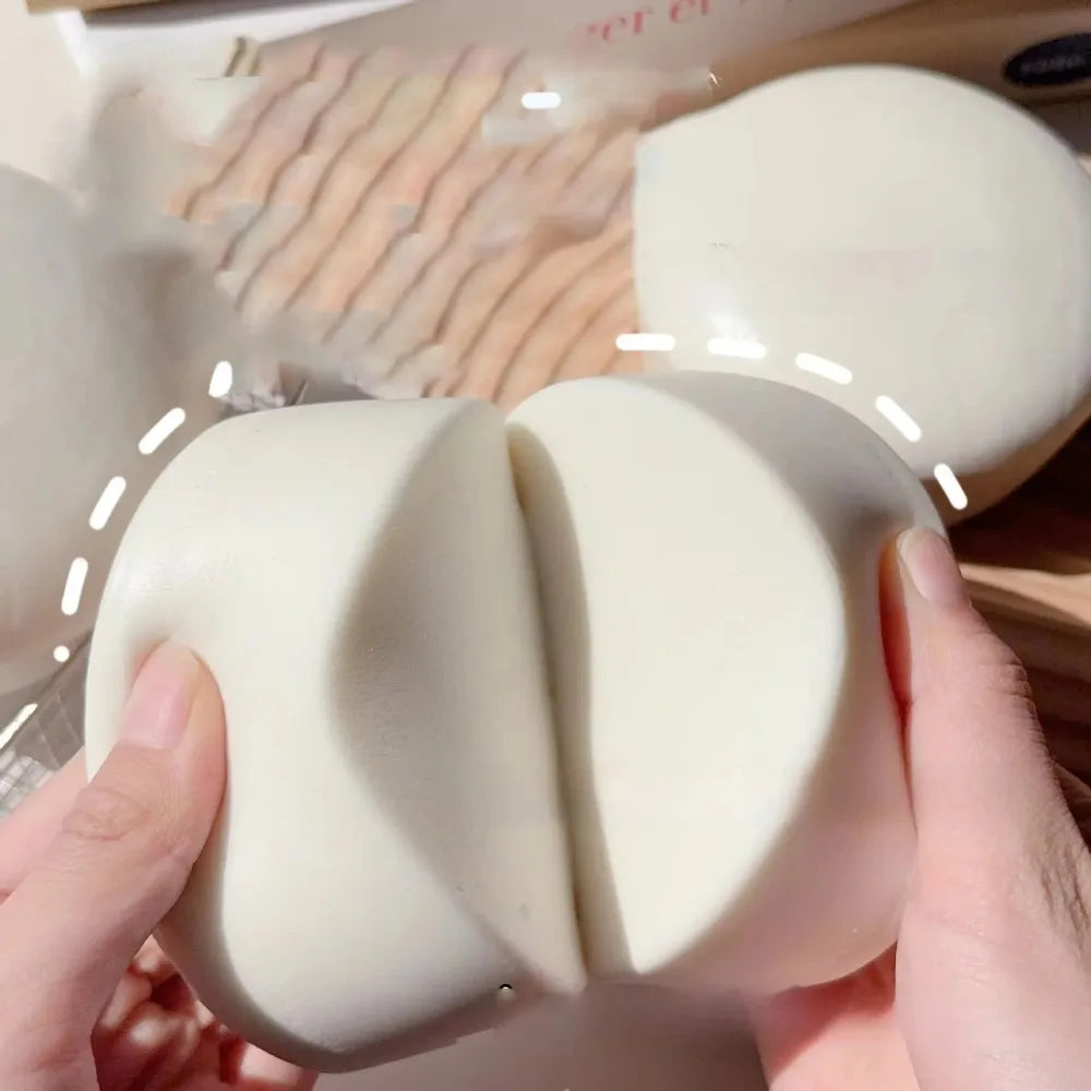 A hand is squeezing a white yogurt cake squishy stress relief toy.