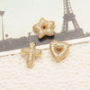 Gold tone crystal heart cross pendant jewelry displayed on a light background with the Eiffel Tower in the background