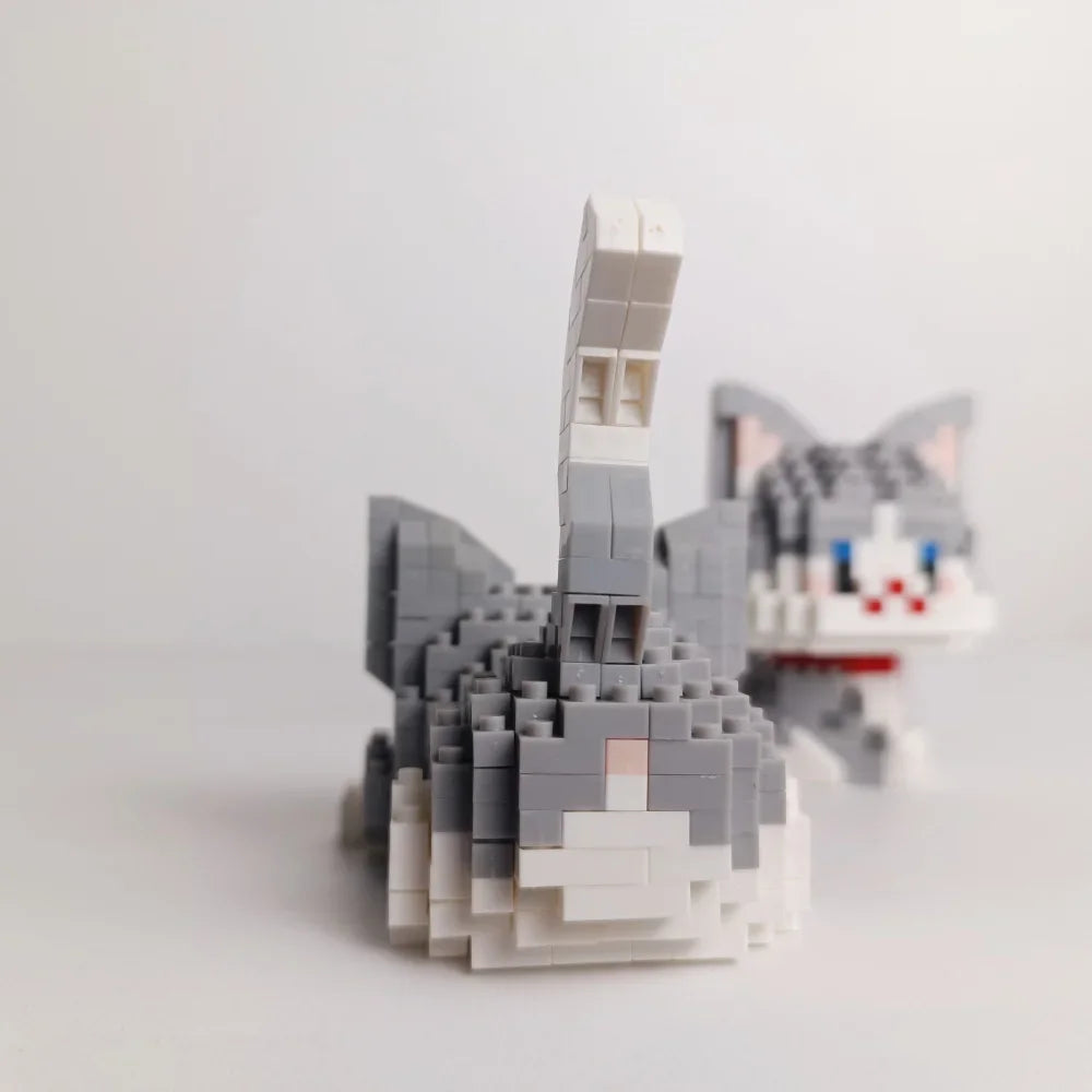 A gray and white building block model of a cat, resembling a stylized feline figure.