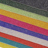 A close-up view of various colored sparkling rhinestone adhesive tape strips stacked horizontally.