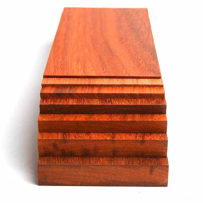 A stack of natural African red rosewood boards showing various grain patterns and cuts.