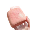 A pink sticky cube slow-rising squishy stress relief toy held in a hand.