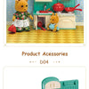 A miniature dollhouse kitchen set featuring green cabinetry, red pots, and yellow animal figures.