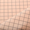 Close-up of beige grid print fabric with diagonal stitching detail.