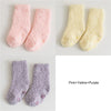 Three pairs of baby anti-slip fleece socks in pink, yellow, and purple.