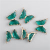 Gold-toned crystal butterfly charm beads with green facets and clear accents for jewelry making