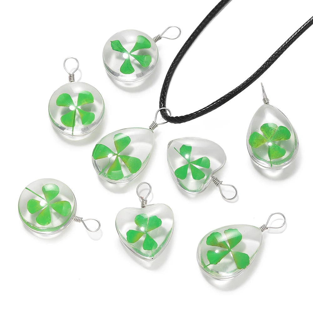 A set of handmade glass four leaf clover pendants on black cord for jewelry making