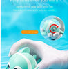 A hand is holding a light green wind-up swimming duck bath toy for toddlers.
