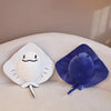 A pair of soft plush toys shaped like a ray and a devil fish, white and deep blue, resting on a light-colored surface.