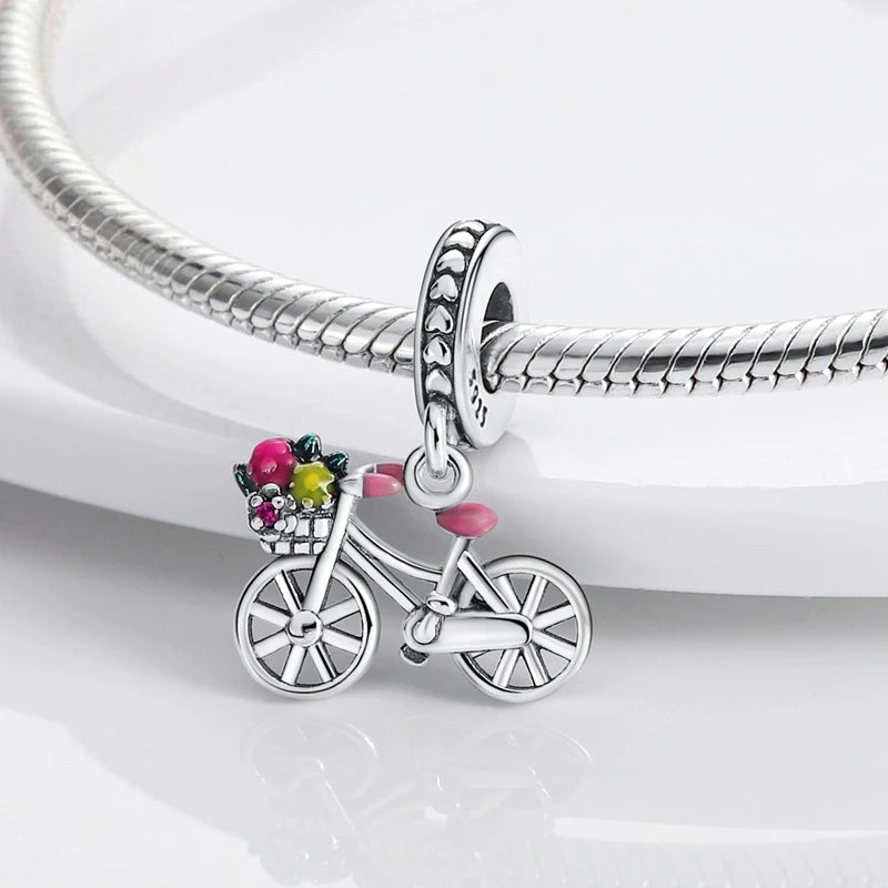 Sterling silver charm bead pendant featuring a bicycle, key, and other charms attached to a silver chain.