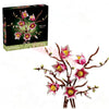 A box of Everlasting Flower Building Block Bouquet Set featuring pink and yellow flowers on a dark background.