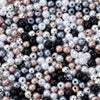 A close-up of mixed colored pearl beads in silver, gray, black, and rose gold tones.