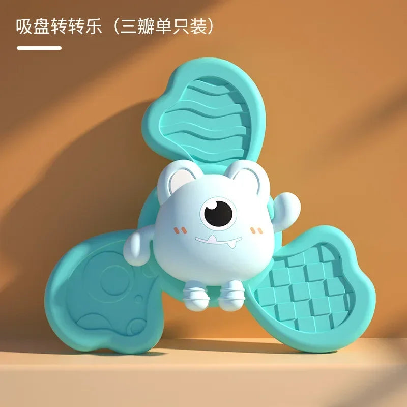 A cute white animal shaped bath toy with suction cup spinners, shown in light blue on a wooden surface.