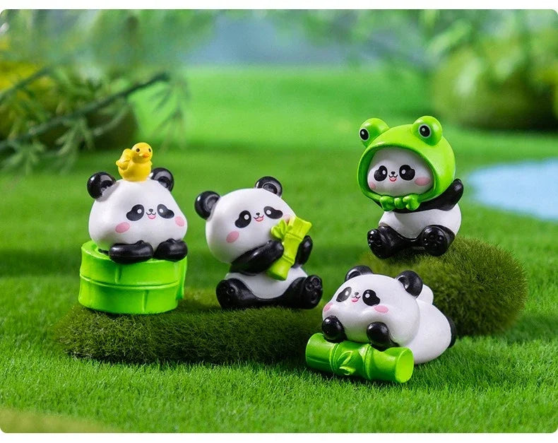 A set of adorable resin panda figurines, including a standing panda and a sitting panda, displayed on green grass.