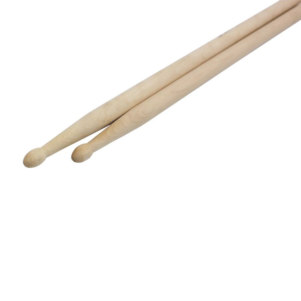 Three maple wood drumsticks of different sizes laid diagonally against a white background.