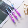 A pair of iridescent diamond painting tools or applicators resting on a magazine page.