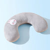 A soft gray U-shaped plush pillow with a pink face design for neck support.