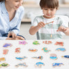 A child is playing with a set of wooden magnetic fishing game pieces on a white surface.