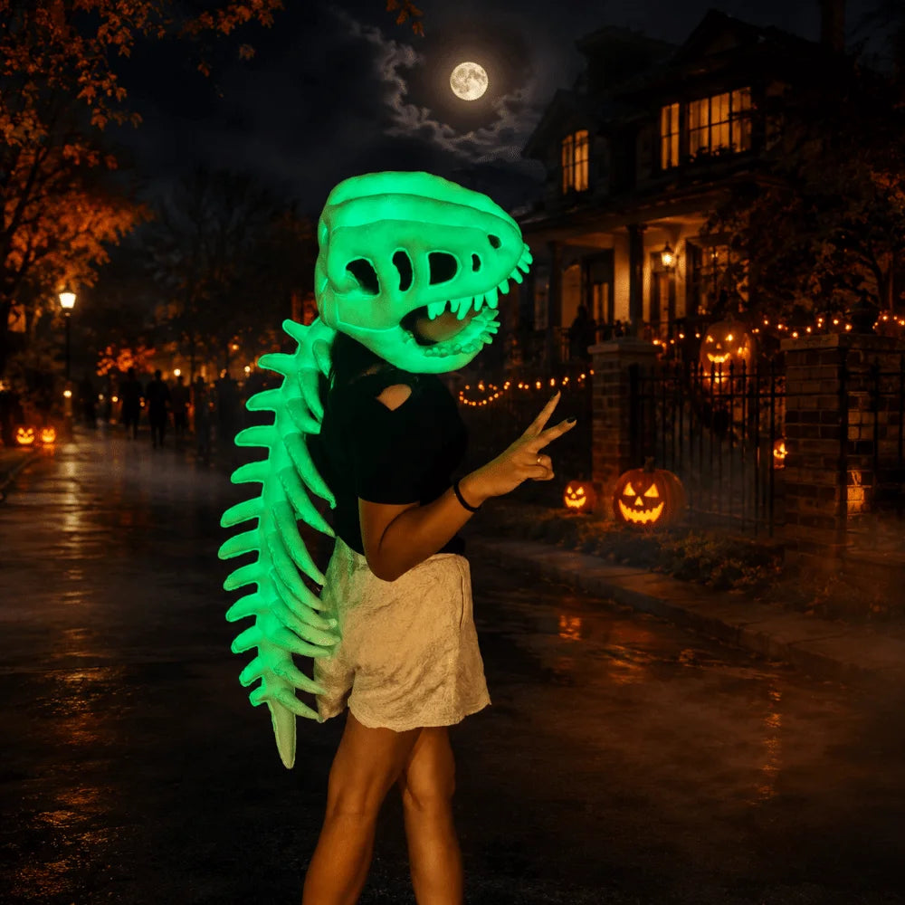A person wearing a glow-in-the-dark dinosaur skeleton mask stands in a dark, foggy outdoor setting under a full moon.