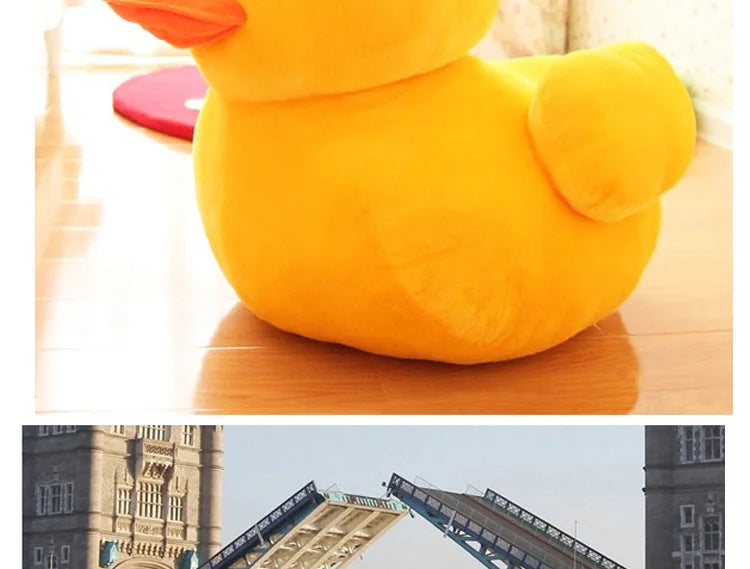 A bright yellow plush toy shaped like a duck resting on a wooden surface.