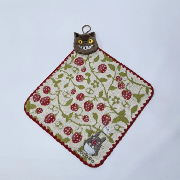 A handmade embroidered patch featuring a cat head and red berries on a green background.