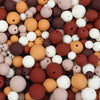 A close-up view of various matte acrylic beads in shades of brown, beige, and white.