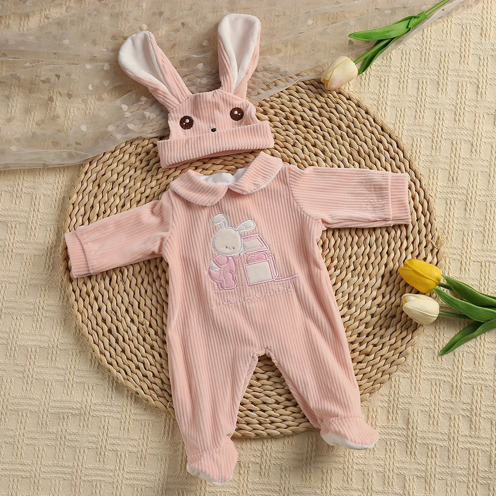 A pink bunny romper set for a baby doll lying on a woven mat with yellow flowers.