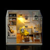 A wooden miniature dollhouse kit displayed in a glass box with interior shelving and furniture.