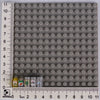 A grid of gray building blocks with a ruler showing dimensions, including small food-themed bricks at the bottom.