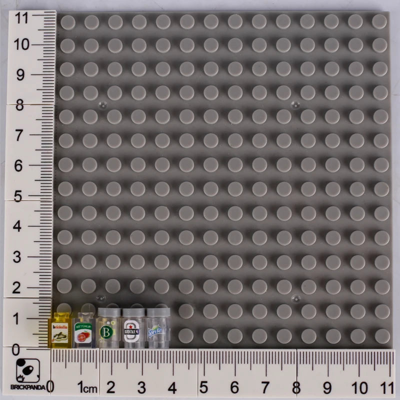 A grid of gray building blocks with a ruler showing dimensions, including small food-themed bricks at the bottom.
