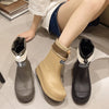 A pair of tan and black waterproof mid-calf rain boots displayed on a light surface.