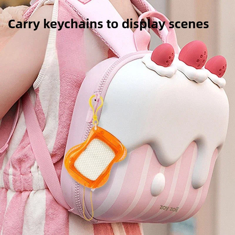 A pink and white striped backpack features a mini magnetic drawing board keychain with an orange stylus attached.
