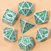 A set of seven fantasy carved polyhedral dice in white and green on a light background.