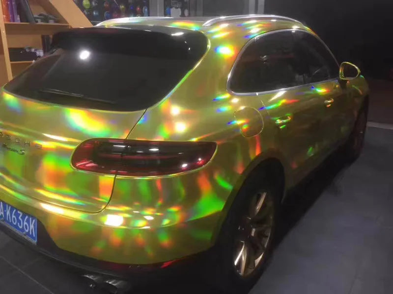 A yellow car with a holographic chrome vinyl wrap finish parked indoors.