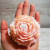 A hand holds a pink peony flower silicone mold for baking, chocolate, soap, and craft.