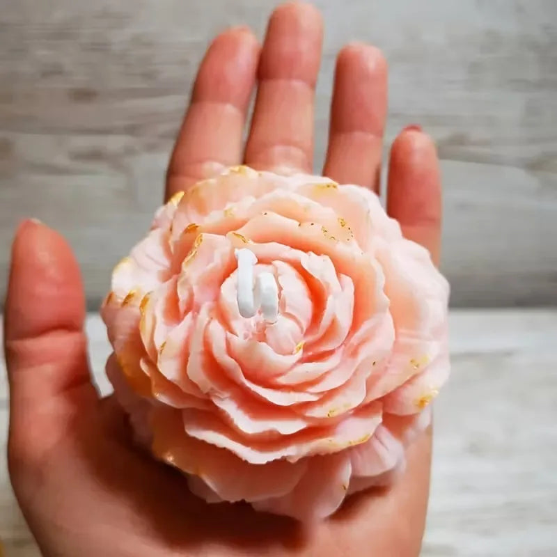 A hand holds a pink peony flower silicone mold for baking, chocolate, soap, and craft.
