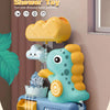 A yellow dinosaur bath toy sprinkler is shown spraying water onto a blue dinosaur figure in a bathroom setting.