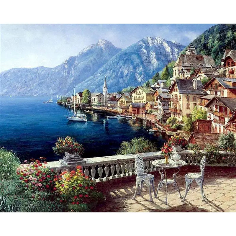 A painting depicting a scenic coastal town with buildings on a hillside overlooking a blue sea and mountains.