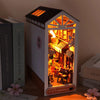 A wooden miniature bookshelf book nook kit with an illuminated diorama display.