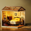 A DIY miniature dollhouse kit of a sweet dream bedroom with LED lighting displayed on a wooden surface.