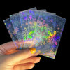 A hand holds a fan of holographic card sleeves featuring colorful snowflake designs.