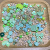 A collection of mixed green and clear acrylic loose beads for jewelry making