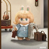 A blonde rabbit-eared plush toy wearing a blue collared shirt standing next to several brown leather suitcases.