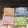 A set of colorful cartoon animal keycap keychains arranged in various layouts for stress relief.