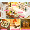 A miniature wooden dollhouse kit featuring furniture, pillows, and decorative items.