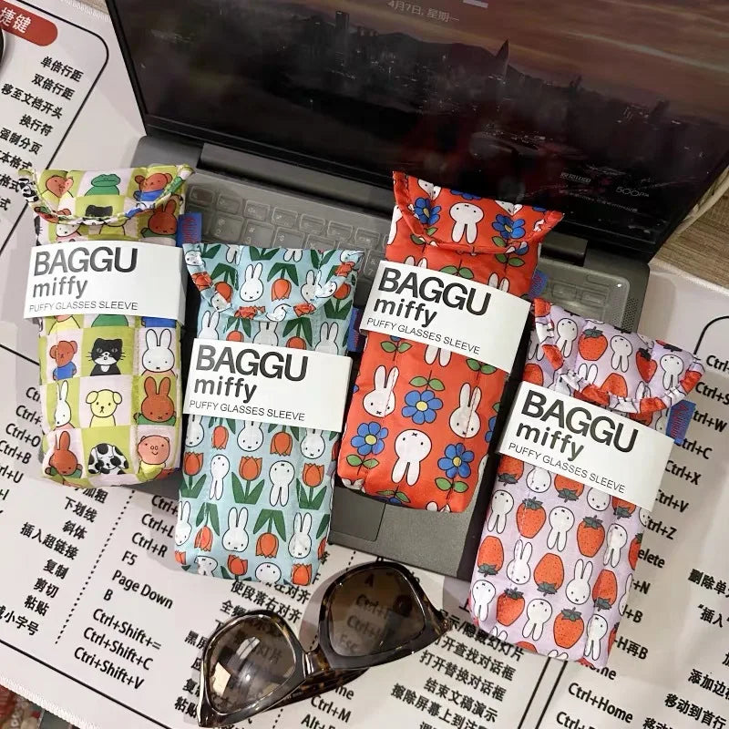 A collection of BAGGU miffy puffy glasses sleeves in various floral patterns displayed in a laptop case.
