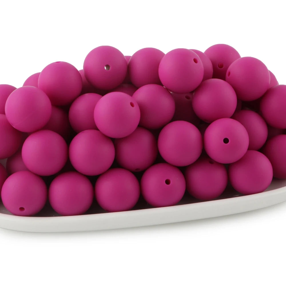 A pile of bright pink round silicone beads for jewelry making and DIY crafts.